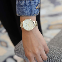 Reloj de pulsera con detalles de cristal para dama marca Nine West. Brazalete metálico color dorado.